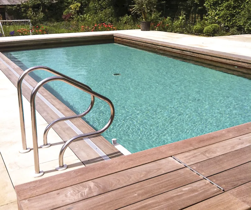 A formal natural pool purified by a plant-free biological filter hidden under the deck